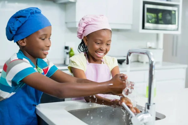 Fratelli lavarsi la mano in cucina a casa — Foto Stock