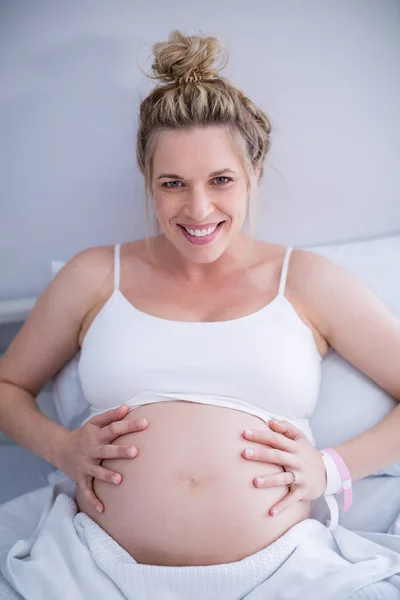 Portrait femme enceinte relaxant sur lit d'hôpital — Photo