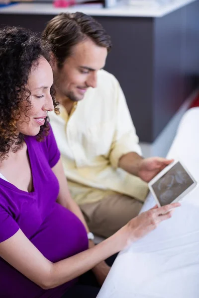 Casal olhando para bebês ultra-som varredura em tablet digital — Fotografia de Stock
