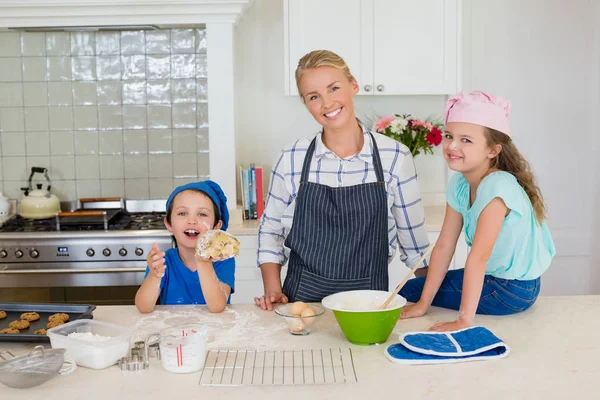 Smiling mother and kids standing in kitchen — Stock Photo, Image
