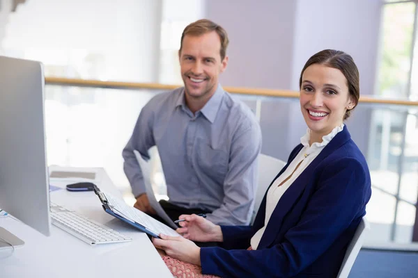 Businesswoman working at desk with colleague — Stock Photo, Image