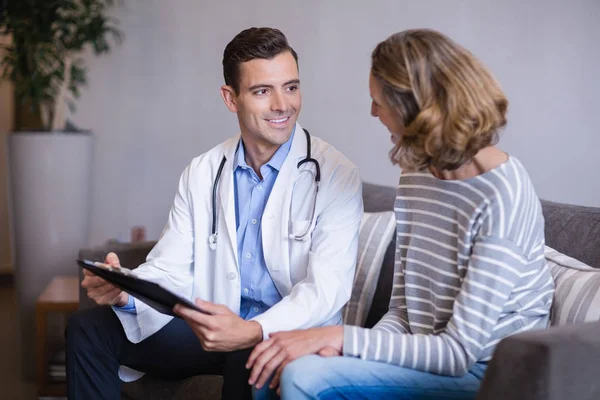 Doctor discutiendo un informe médico con la mujer —  Fotos de Stock