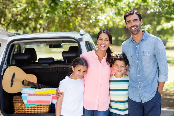 Happy family on a picnic standing next to their car — Stock Photo, Image