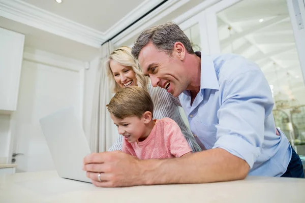 Родители и сын используют ноутбук дома — стоковое фото