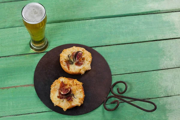 Deliciosa pizza servida em bandeja de pizza com um copo de cerveja — Fotografia de Stock