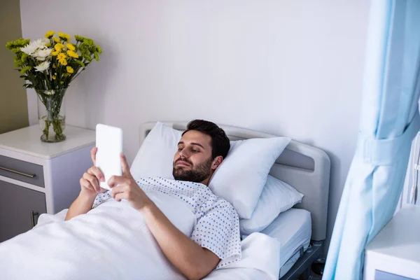 Чоловік пацієнт використовує цифровий планшет у палаті — стокове фото