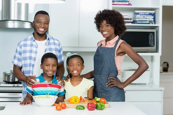 Los padres y los niños de pie en la cocina en casa — Foto de Stock