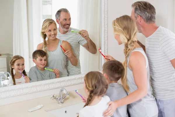 Ouders en kinderen tandenpoetsen in de badkamer — Stockfoto