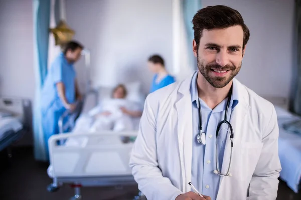 Улыбающийся врач-мужчина стоит в больнице — стоковое фото