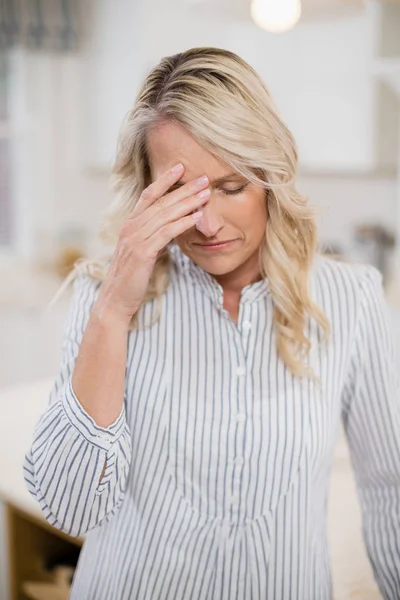 Spänd kvinna med handen på pannan — Stockfoto