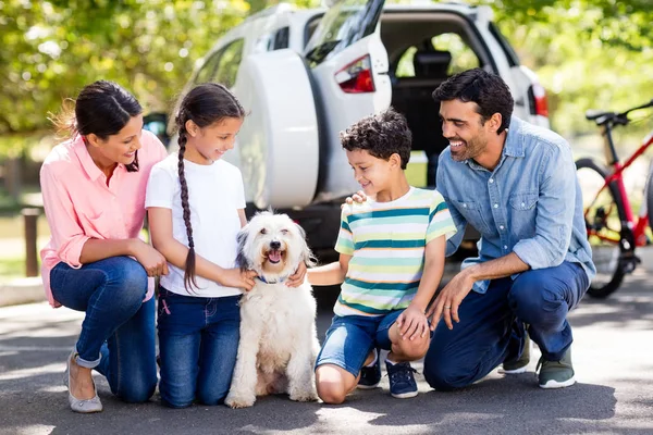 Família feliz desfrutando junto com seu cão de estimação — Fotografia de Stock