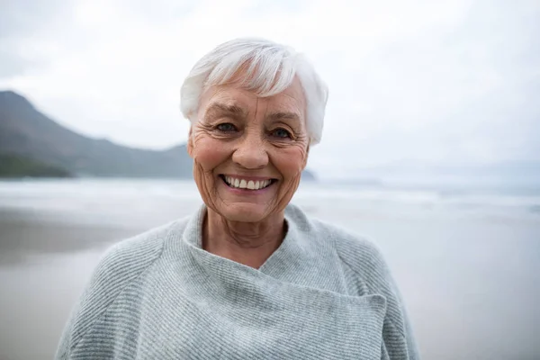 Retrato de una mujer mayor de pie en la playa — Foto de Stock