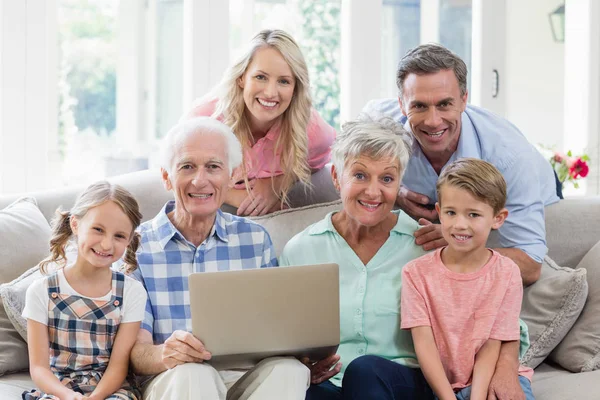 Heureuse famille multi-génération avec ordinateur portable dans le salon — Photo