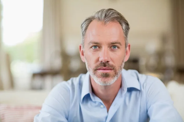 Selbstbewusster Mann sitzt im Wohnzimmer — Stockfoto