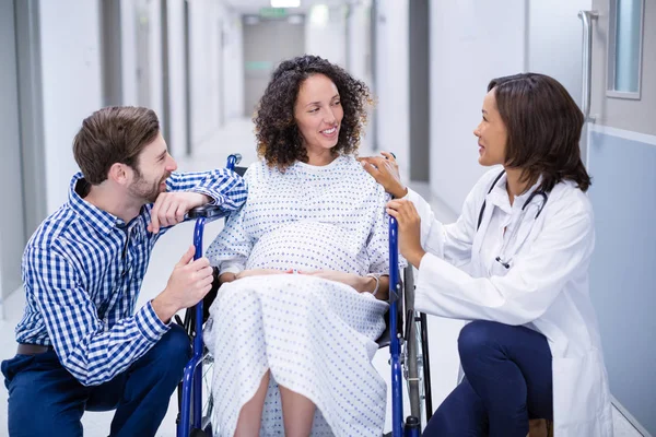 Medico che interagisce con una donna incinta in corridoio — Foto Stock