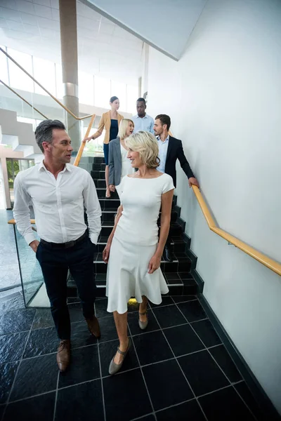 Business executives walking down the stairs — Stock Photo, Image