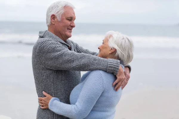 Äldre par stående tillsammans på stranden — Stockfoto