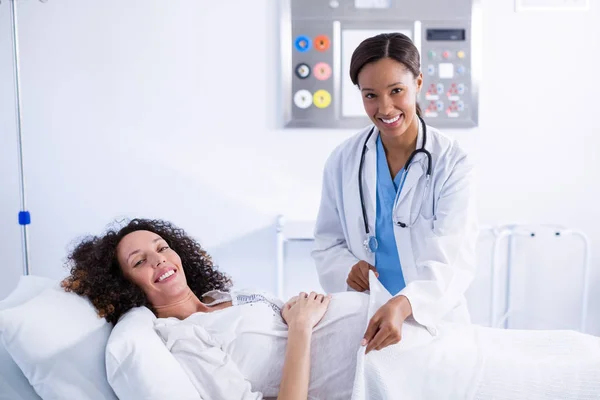 Portrait of doctor putting blanket on pregnant woman — Stock Photo, Image