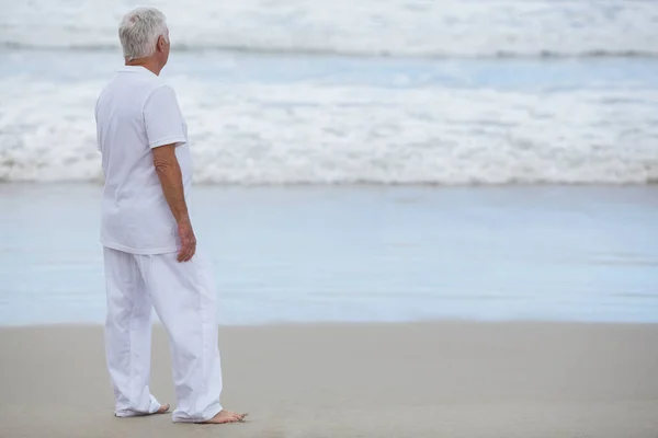 Älterer Mann steht am Strand — Stockfoto