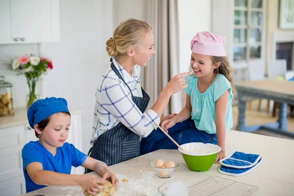 Mother and kids having fun while making dough in kitchen — Stock Photo, Image