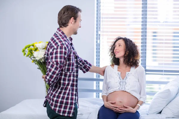 Man verbergen bos bloemen achter zijn rug in een afdeling in ward — Stockfoto