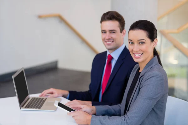 Happy business executives sitting at desk — Stock Photo, Image