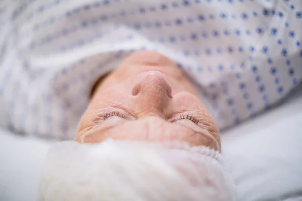 Senior woman patient sleeping on bed — Stock Photo, Image