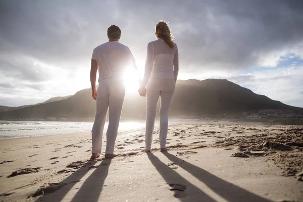 Par stående med att hålla händerna på stranden — Stockfoto