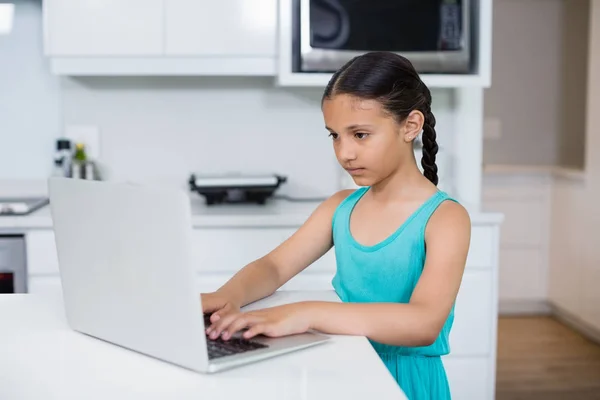 Mutfakta dizüstü bilgisayar kullanan kız — Stok fotoğraf