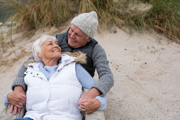 年长的夫妇一起坐在沙滩上 — 图库照片