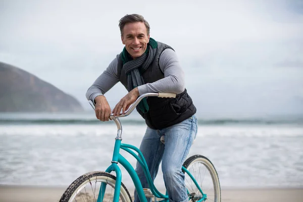 Retrato de hombre maduro montando bicicleta en la playa — Foto de Stock