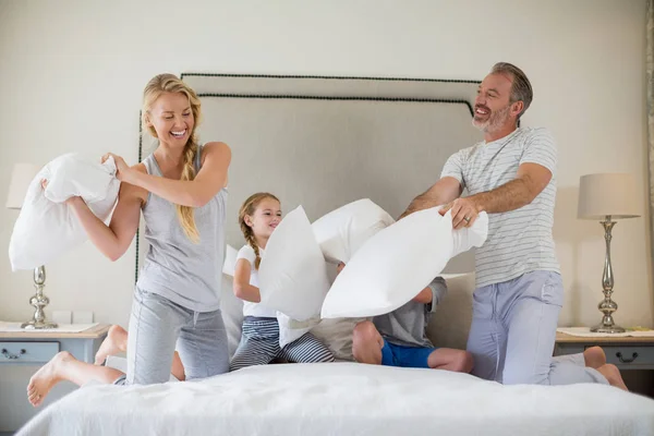 Família bonito ter uma luta travesseiro no quarto — Fotografia de Stock