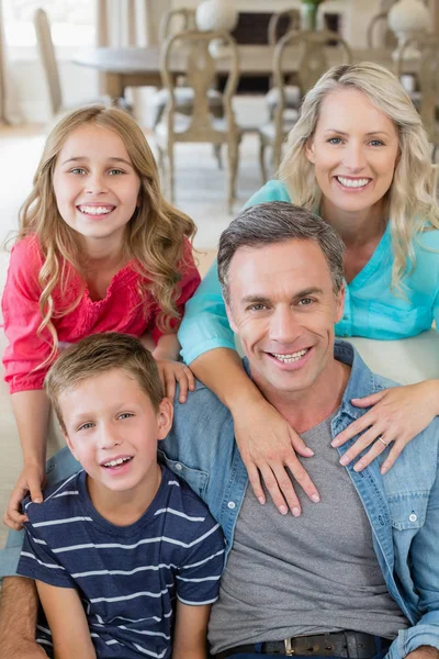 Portret uśmiechający się rodzice i dzieci w pokoju dziennym — Zdjęcie stockowe