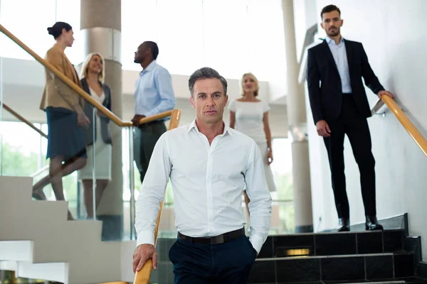 Business executives walking down the stairs — Stock Photo, Image