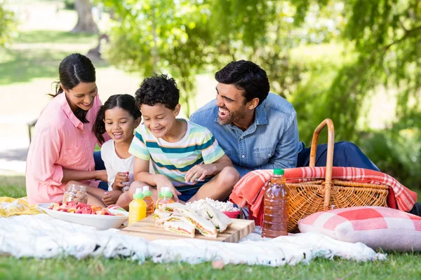 Lycklig familj äter frukost i parken — Stockfoto