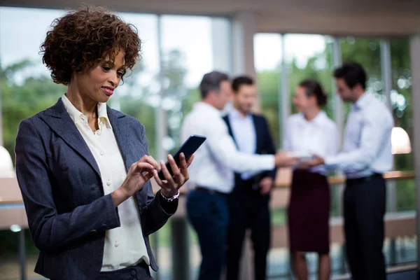 Ejecutiva femenina de negocios usando teléfono móvil — Foto de Stock