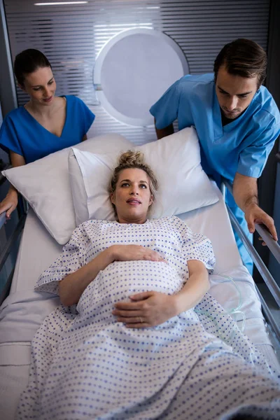 Equipe de médicos que levam mulher grávida para o teatro de operações — Fotografia de Stock