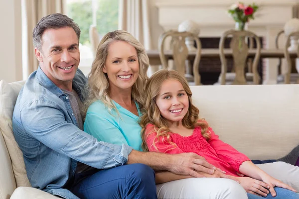 Portrait de parents et fille assis sur le canapé dans le salon — Photo