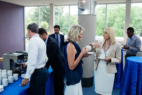 Dirigeants d'entreprise interagissant les uns avec les autres tout en prenant un café — Photo