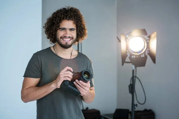 Fotograaf houdt een camera in de studio — Stockfoto