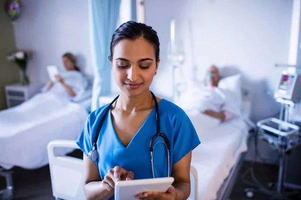 Médica bonita usando tablet digital na enfermaria — Fotografia de Stock