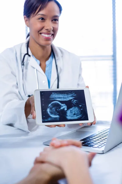 Doctor showing babies ultrasound scan on digital tablet — Stock Photo, Image