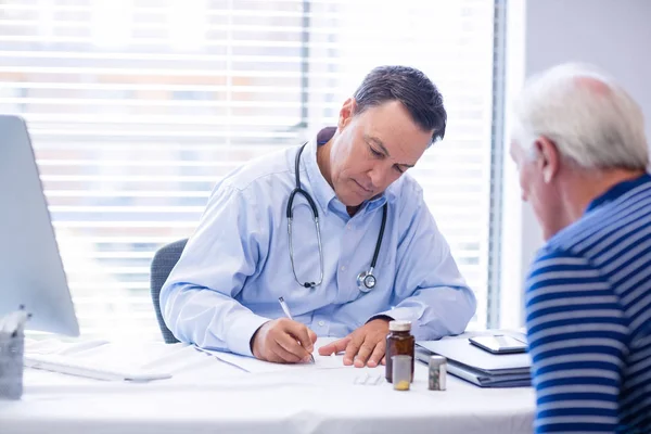 Medico che prescrive medicine a pazienti anziani — Foto Stock