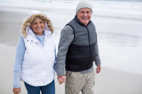 Senioren-Paar geht beim Händchenhalten auf das Meer zu — Stockfoto