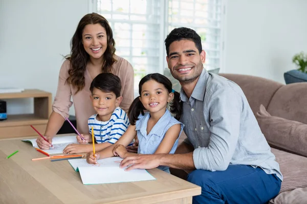 Parents assisting their kids in doing homework at home — Stock Photo, Image