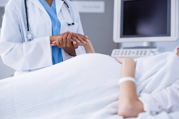 Mid section of doctor comforting pregant woman during ultrasound scan — Stock Photo, Image