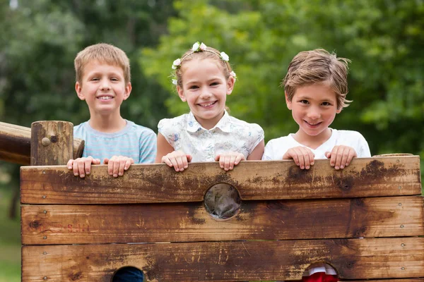 Barn stående på en lekplats rida i park — Stockfoto