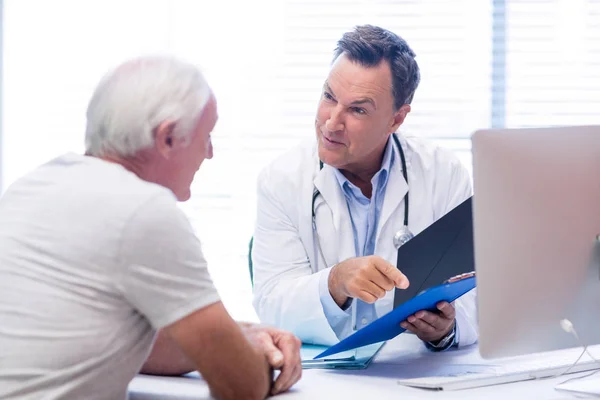 Läkare och senior man diskuterar på fil — Stockfoto