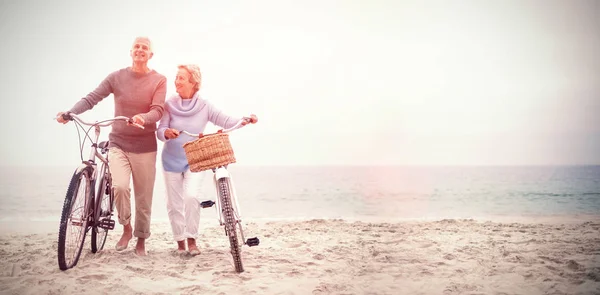 Echtpaar met hun fietsen op strand — Stockfoto
