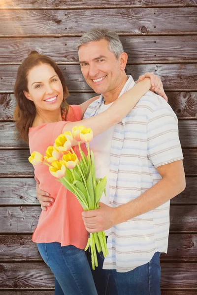 Coppia sorridente con mazzo di fiori — Foto Stock